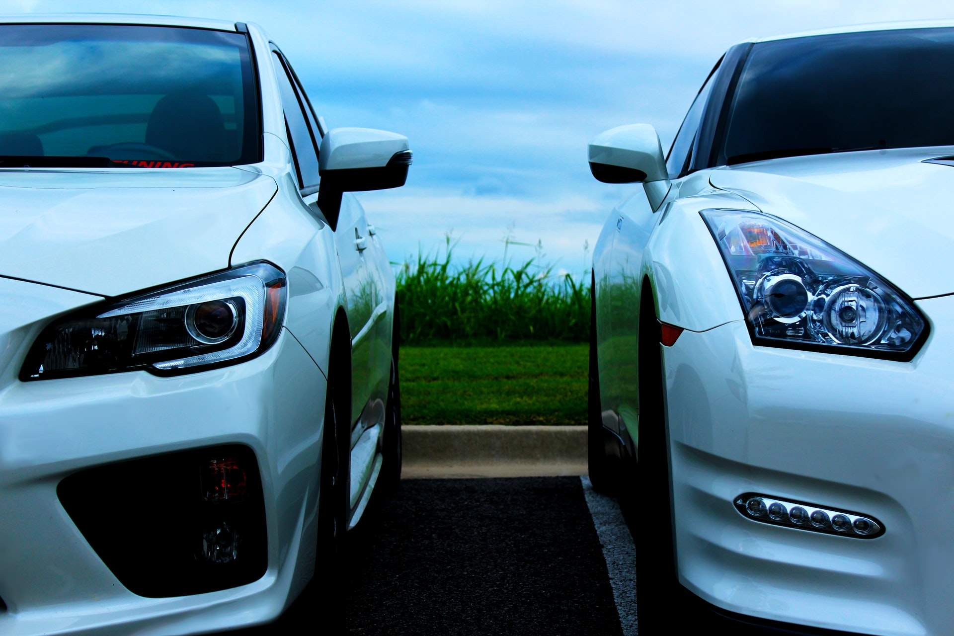 Two white cars parked next to each other