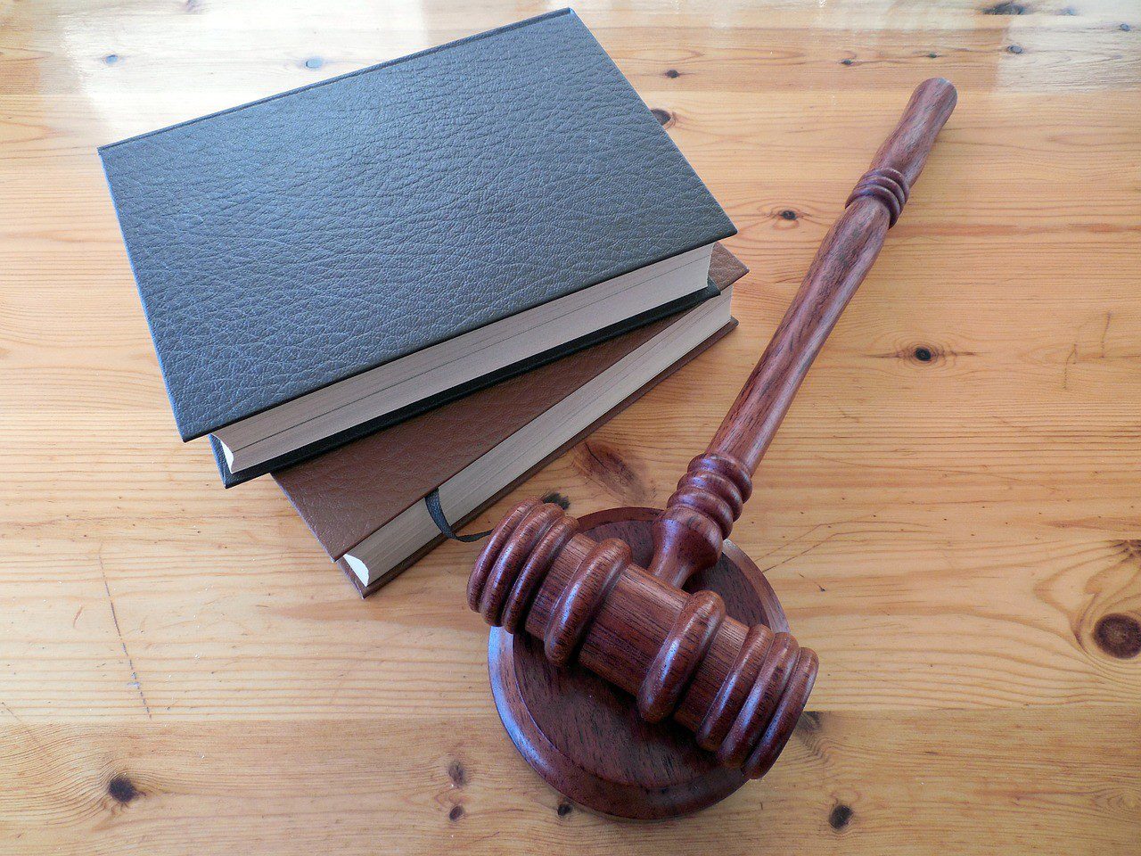 Two books and a gavel on a wooden table