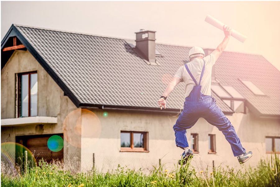 Person jumping in the air in front of a house