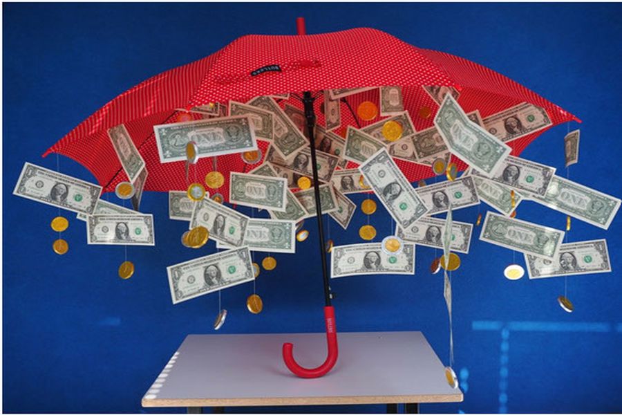 Umbrella protecting dollar bills and coins
