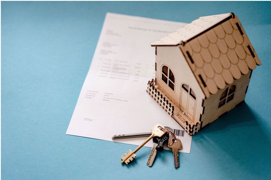 Miniature house with key and real estate contract