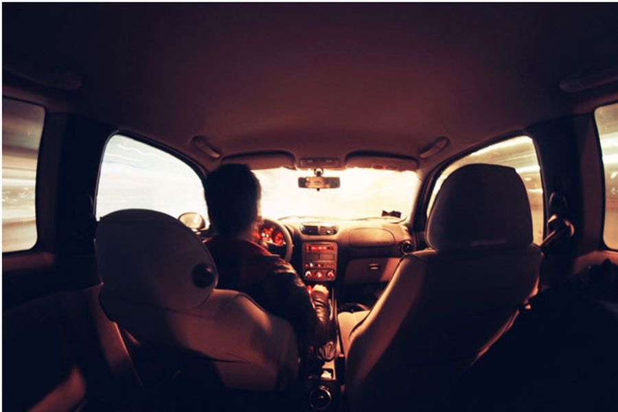 Driver in car seen from backseat