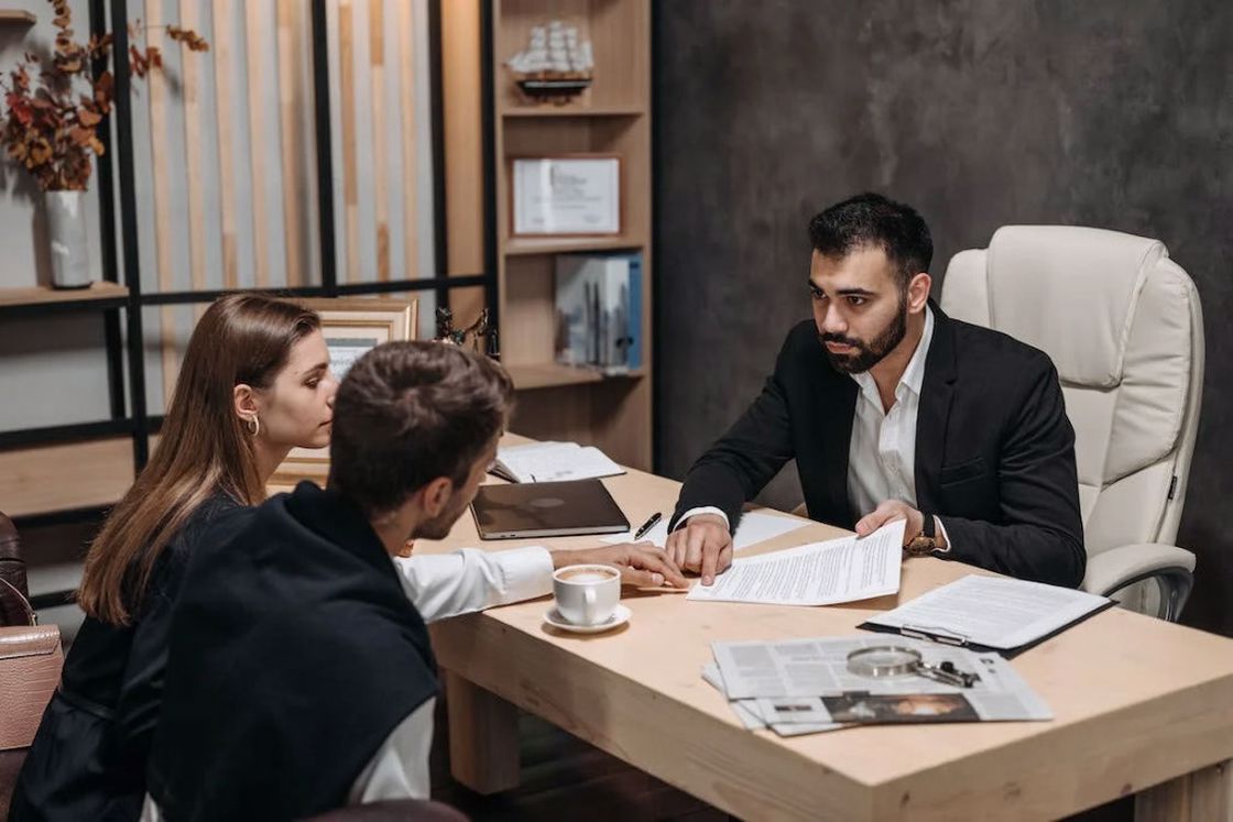 Attorney explaining and pointing something on the contract to his clients