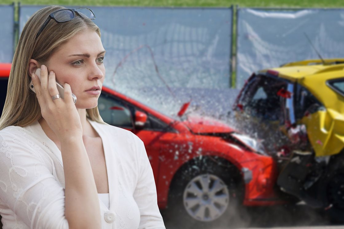 Woman with a white shirt using her silver phone after a car accident