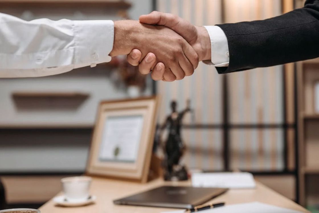 Men in formal suits shaking each others hands in agreement