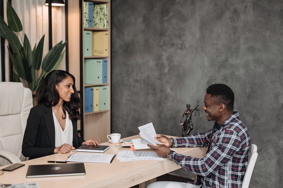 Man holding court documents while in a meeting with his lawyer