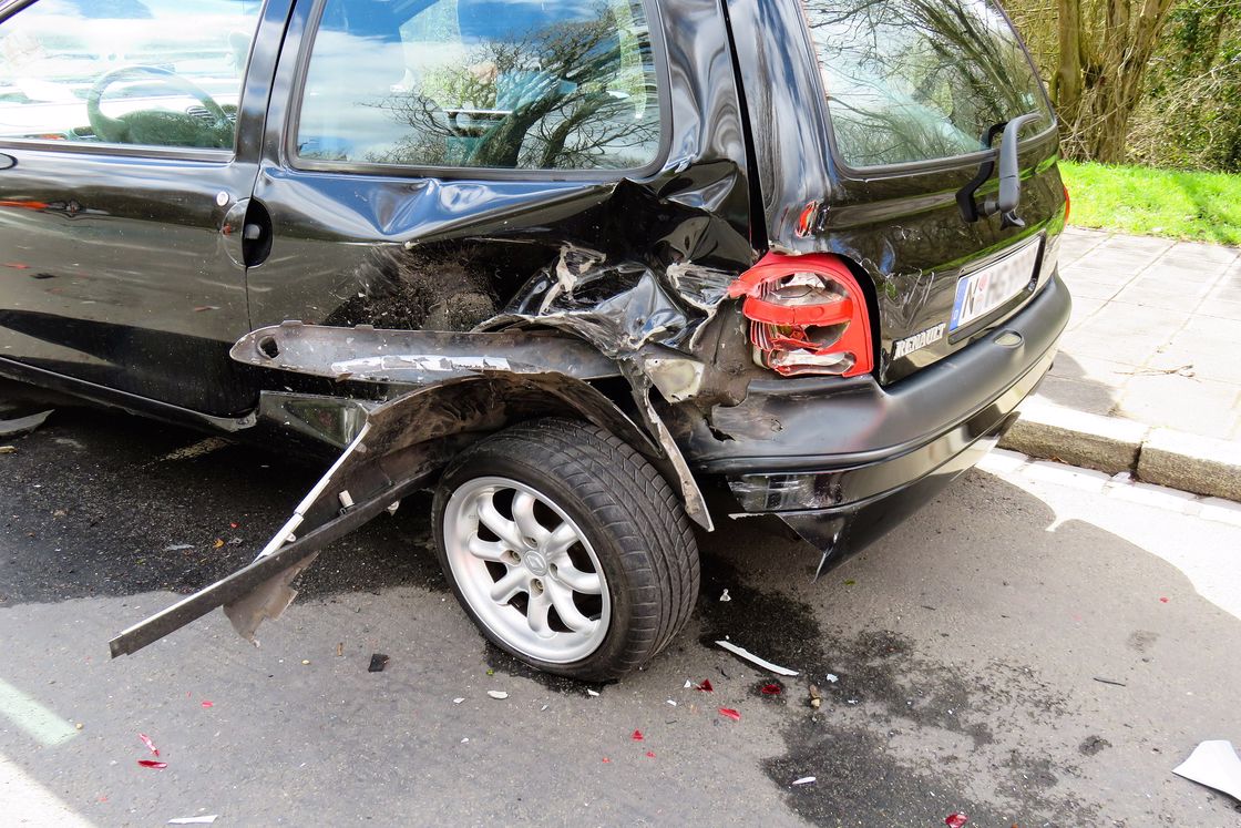 Black car with a smashed bumper