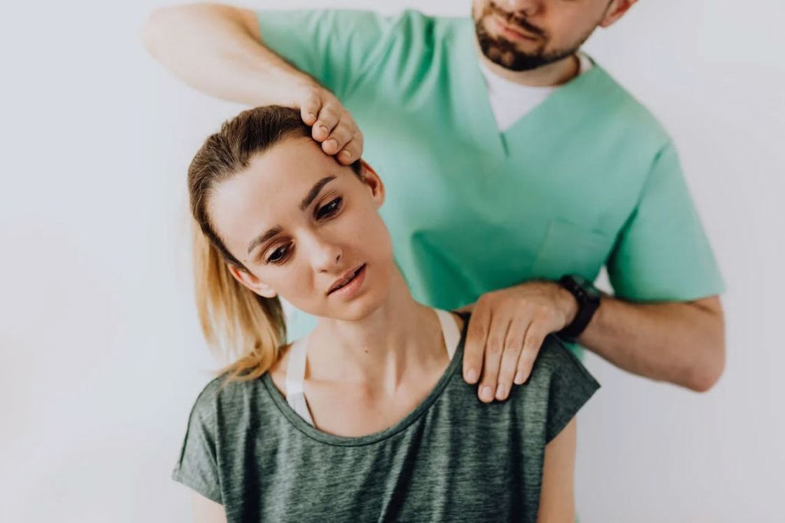 Physical therapist fixing the neck of an injured woman