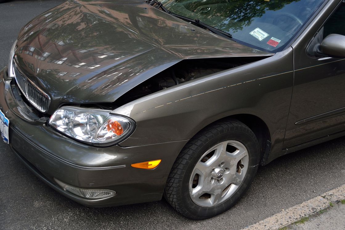 Front hood of a car has visible dent due to a car accident