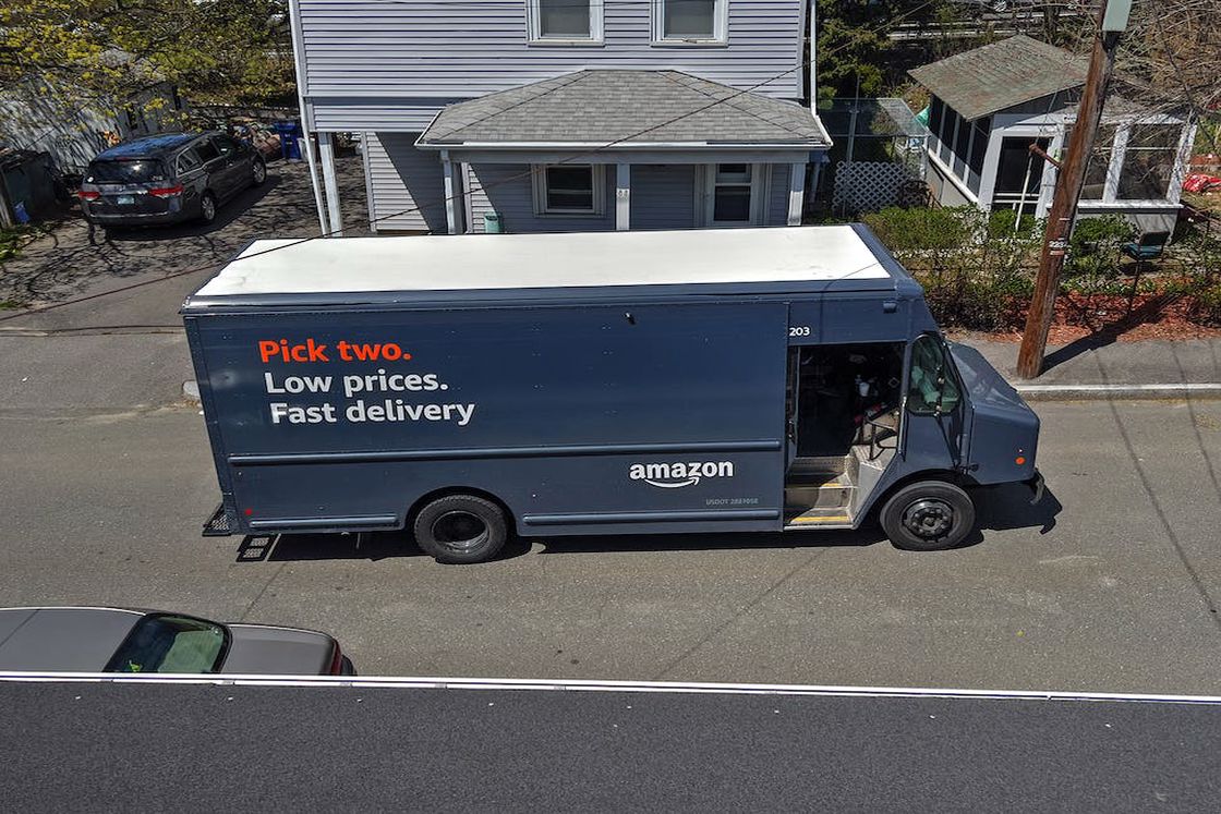 Amazon delivery truck parked in front of a house