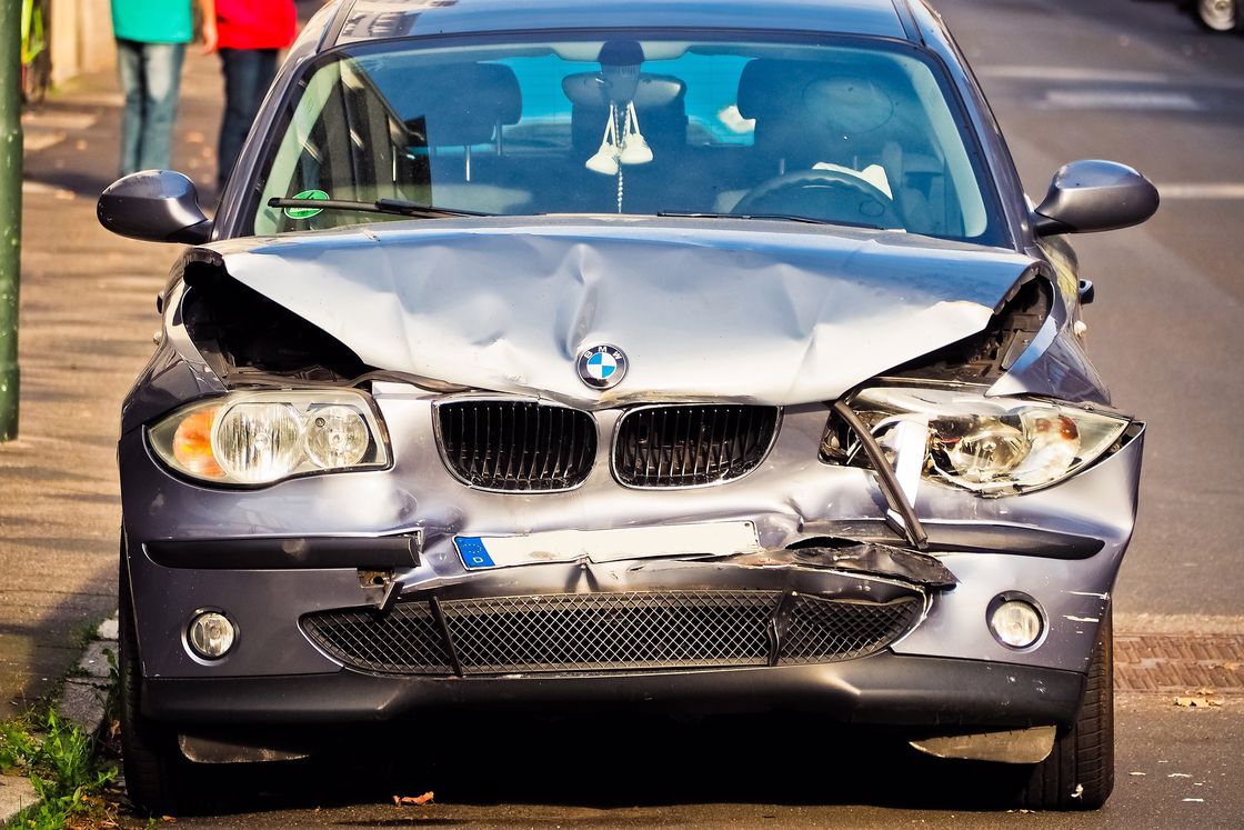 BMW with a heavy dent on its front hood after a car accident