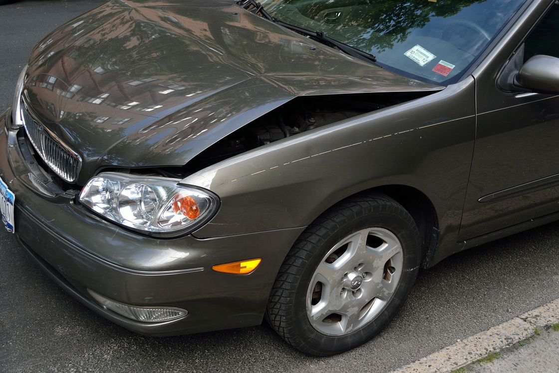 Gray car with a dented front bumper
