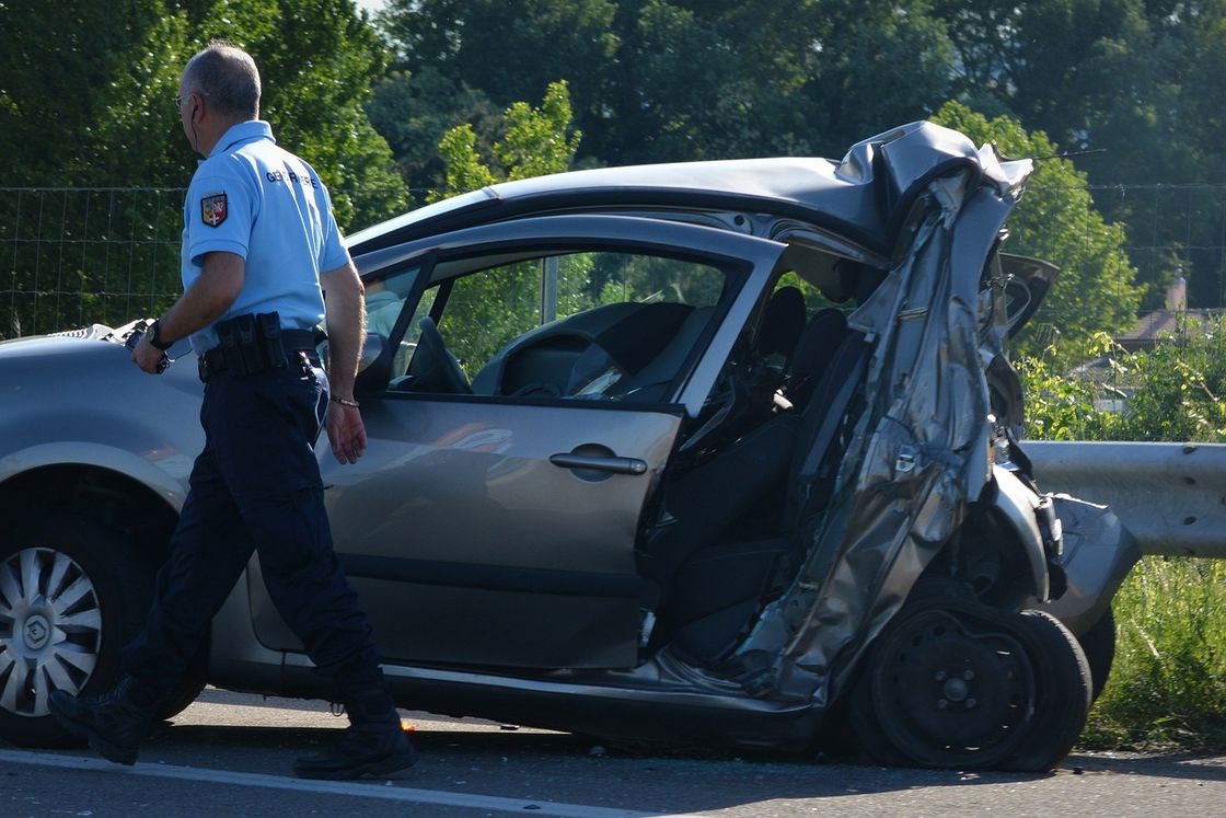 Police inspecting a badly wrecked car after a car accident