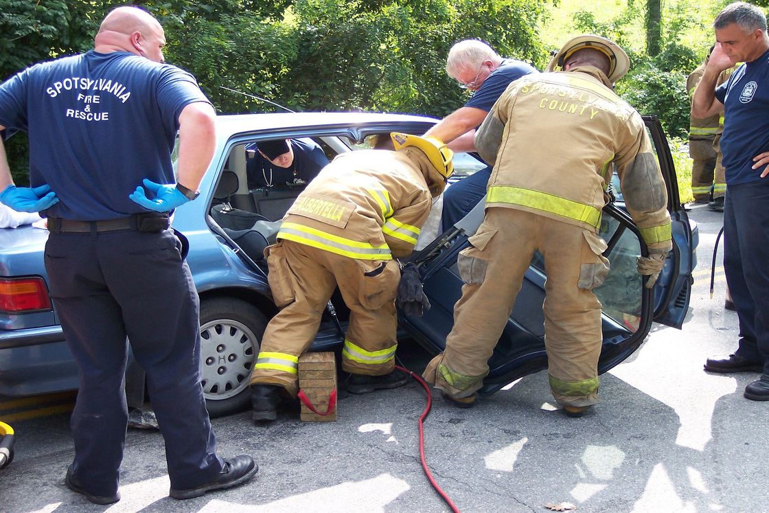 Firefighters taking apart a car to get a badly injured passenger after a collision