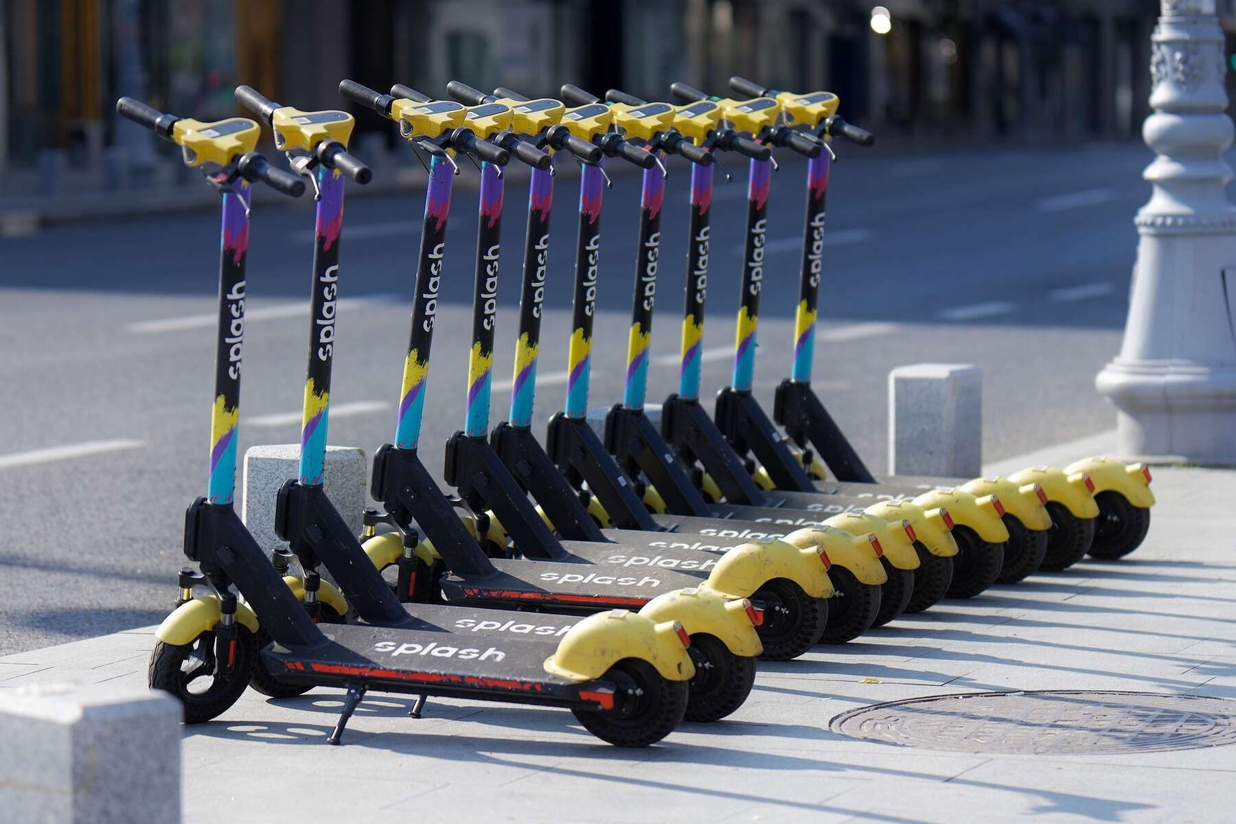 Rows of e scooters lined up in a sidewalk