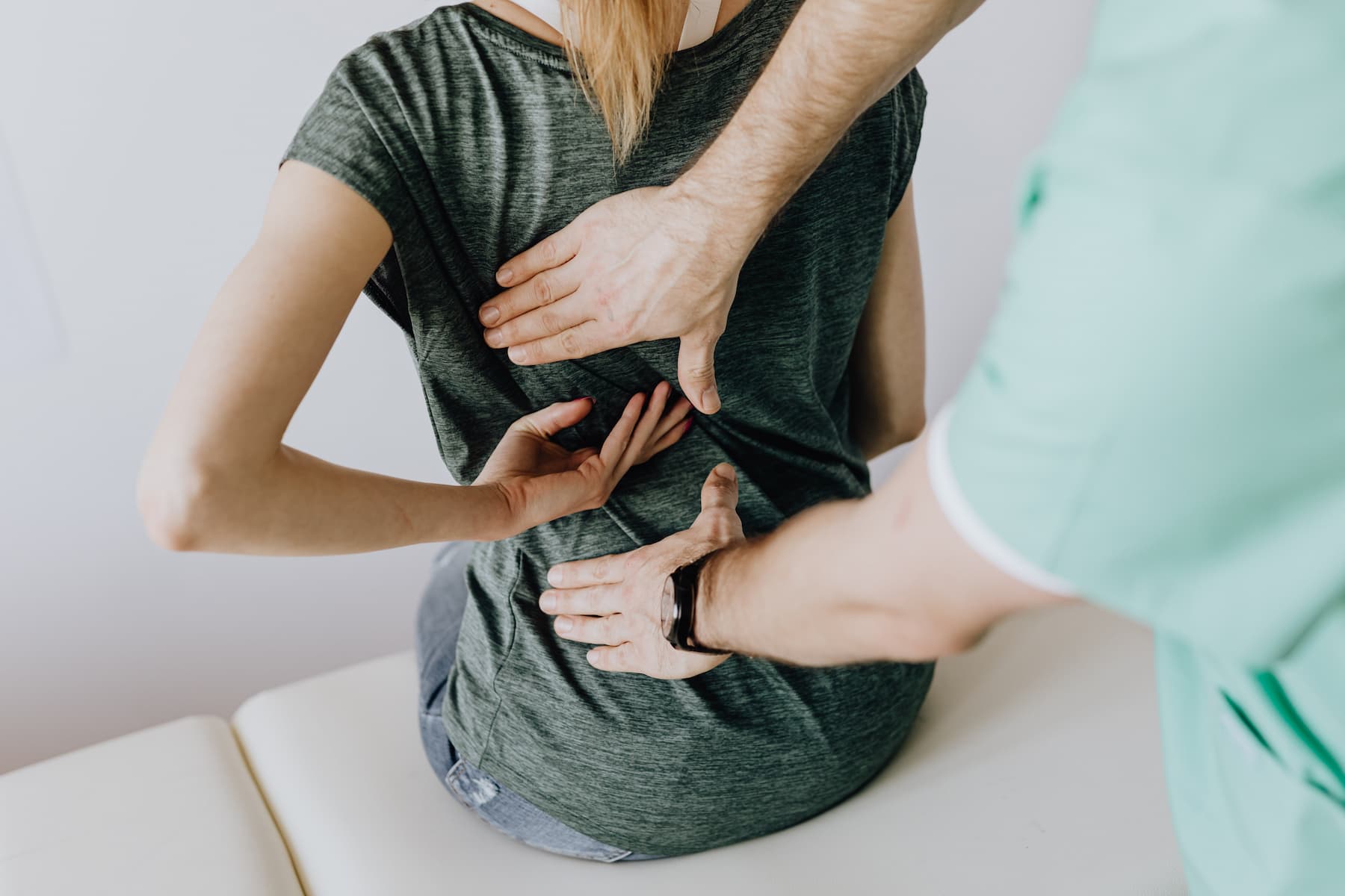 Chiropractor checking the back of a patient