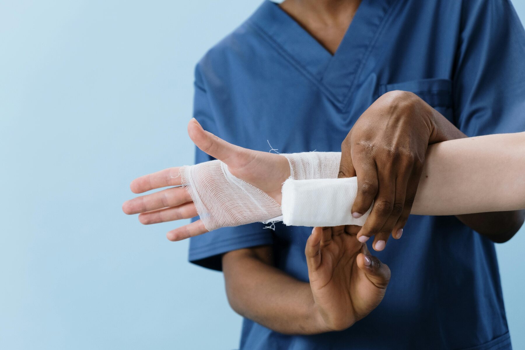 Nurse wrapping a patient's hand with a bandage