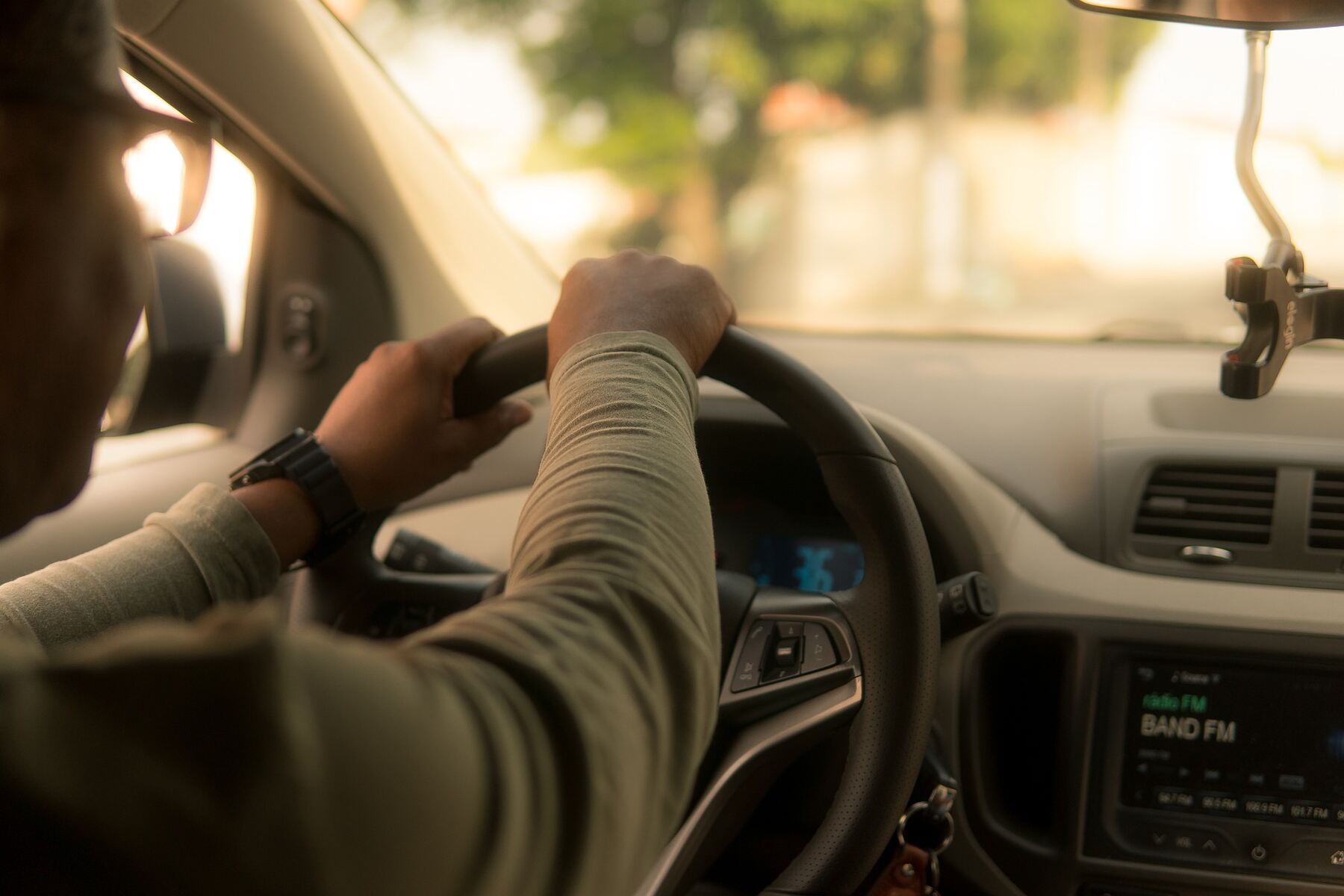 Man with his hands on the steering wheel while driving