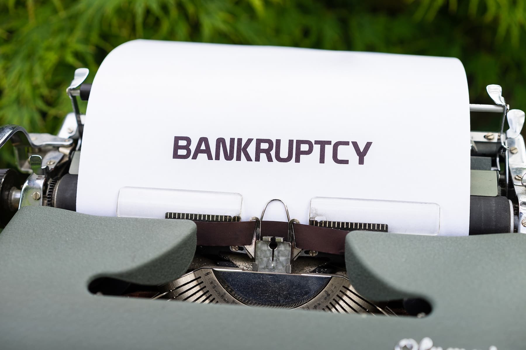 The word bankruptcy is typed on a white bond paper while still inserted on a typewriter