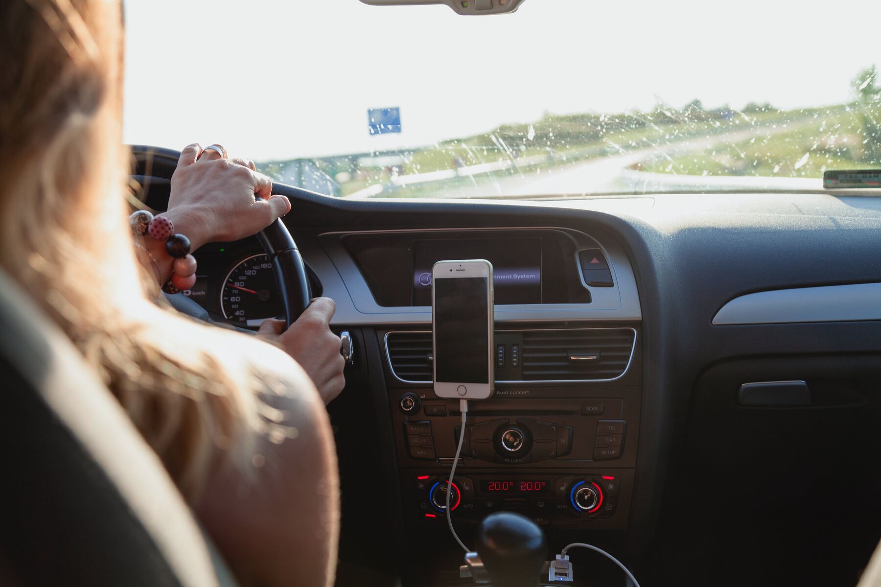 Woman with her hands on the steering wheel while driving her car