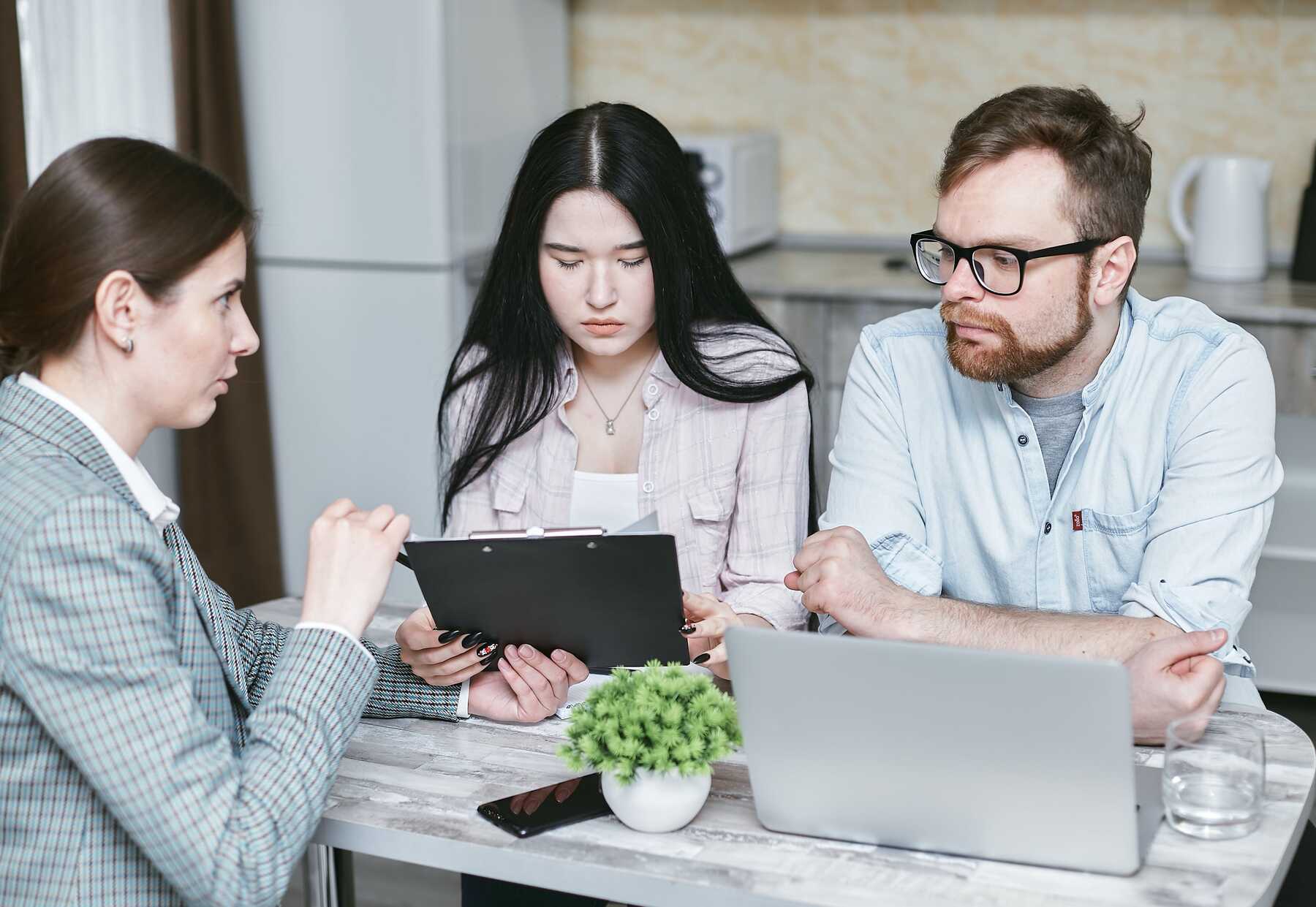 Woman explaining a document to a couple during a meeting