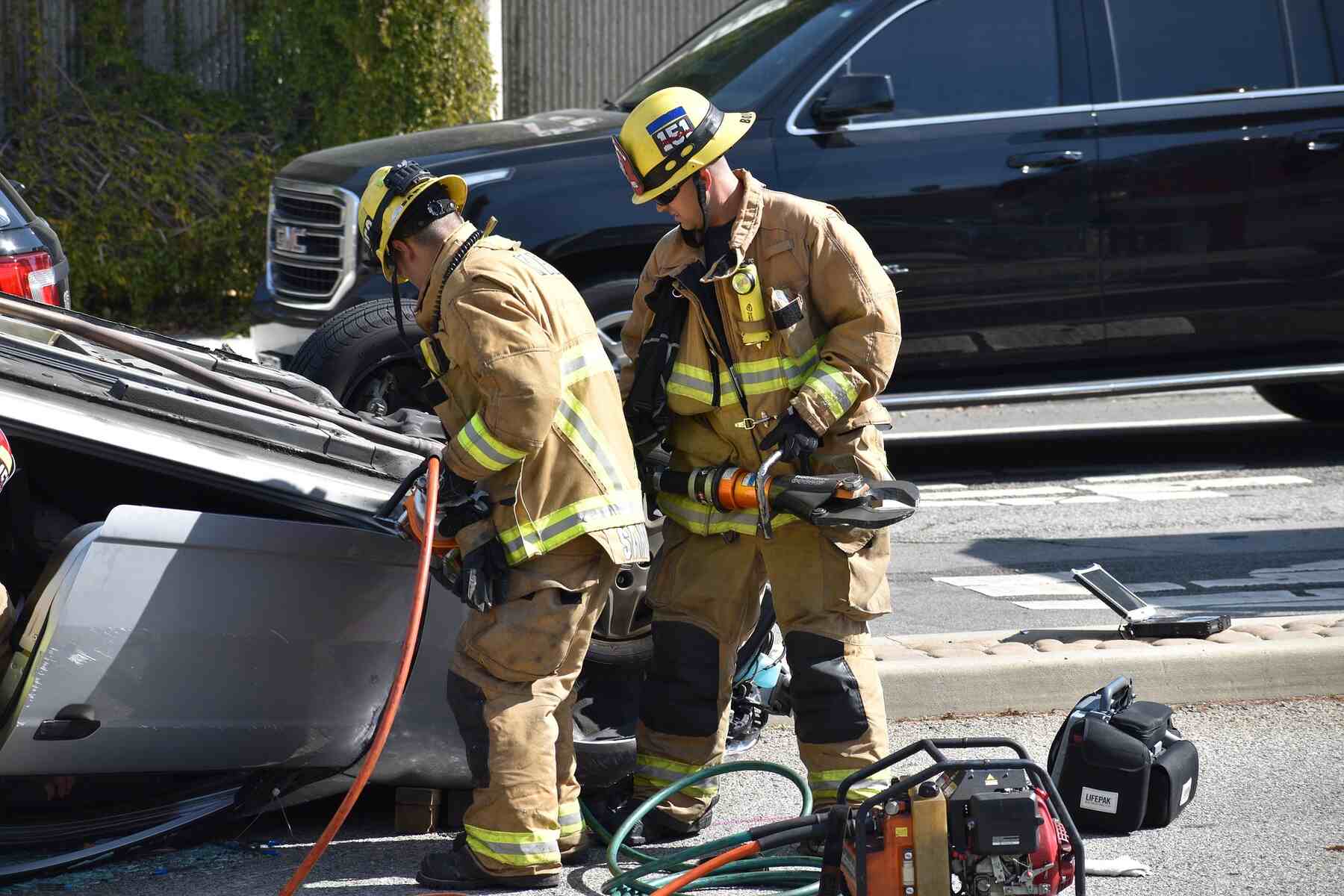 Firefighters prying open an overturned car after an accident