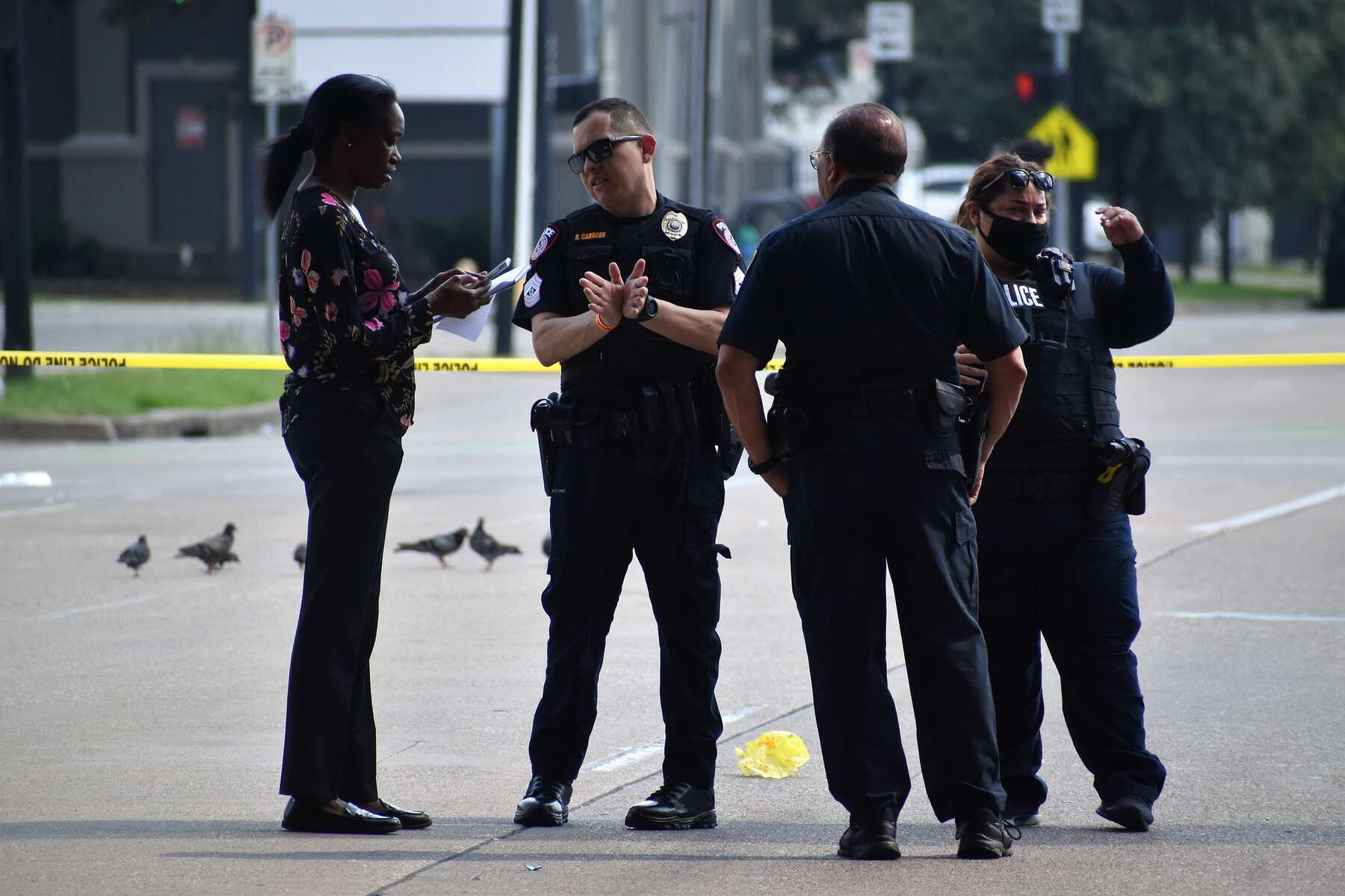 Police officers talking to a woman during a crime scene investigation