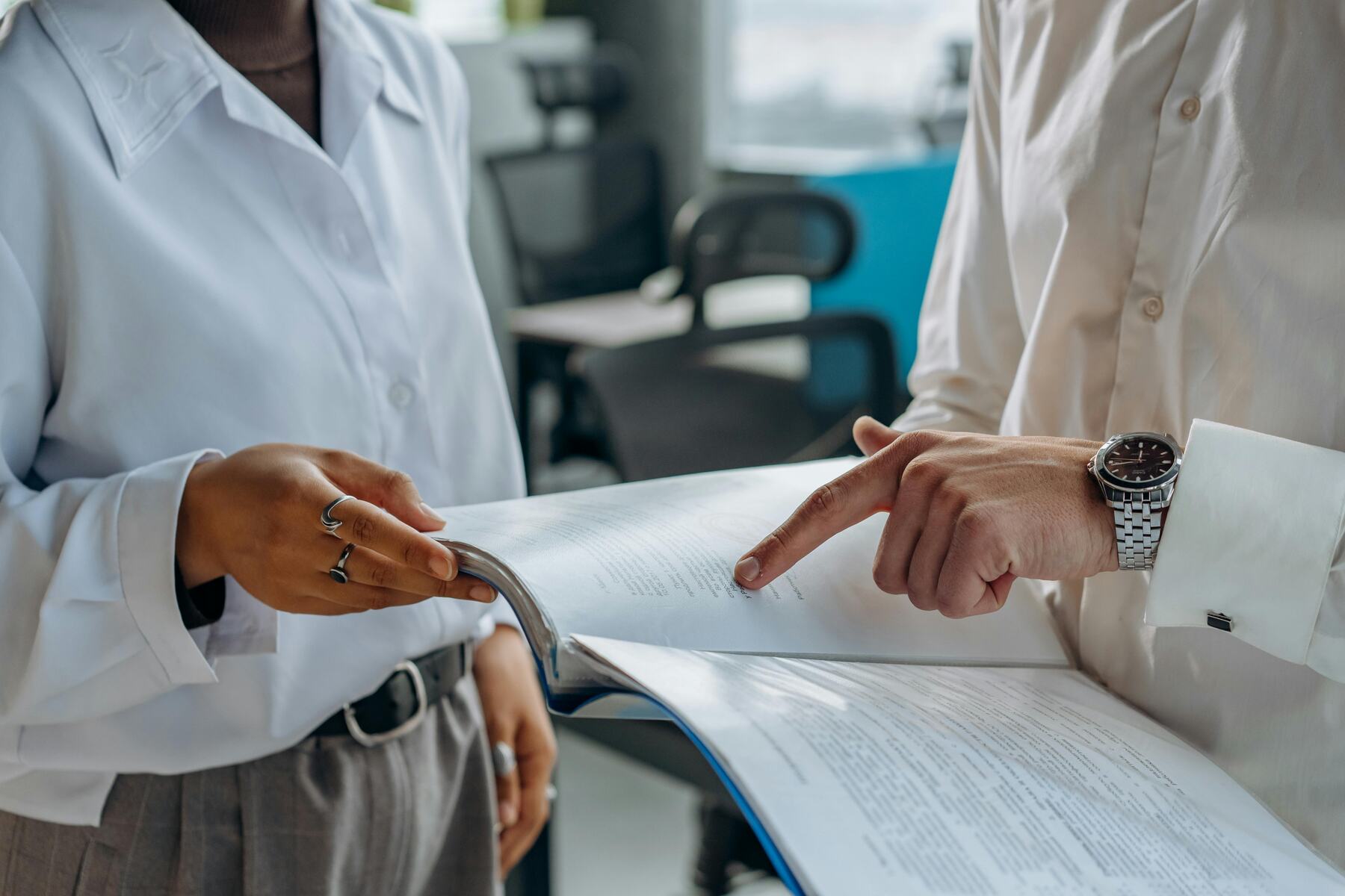 Two people discussing the contents of a printed report