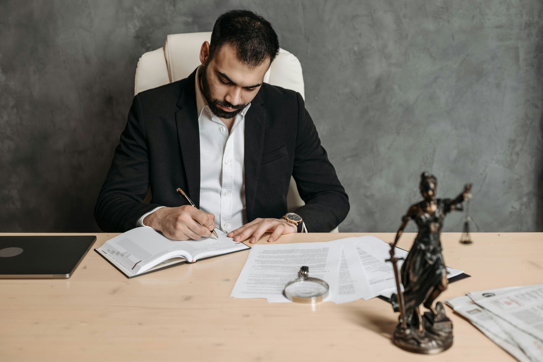 Man in black suit writing on notebook