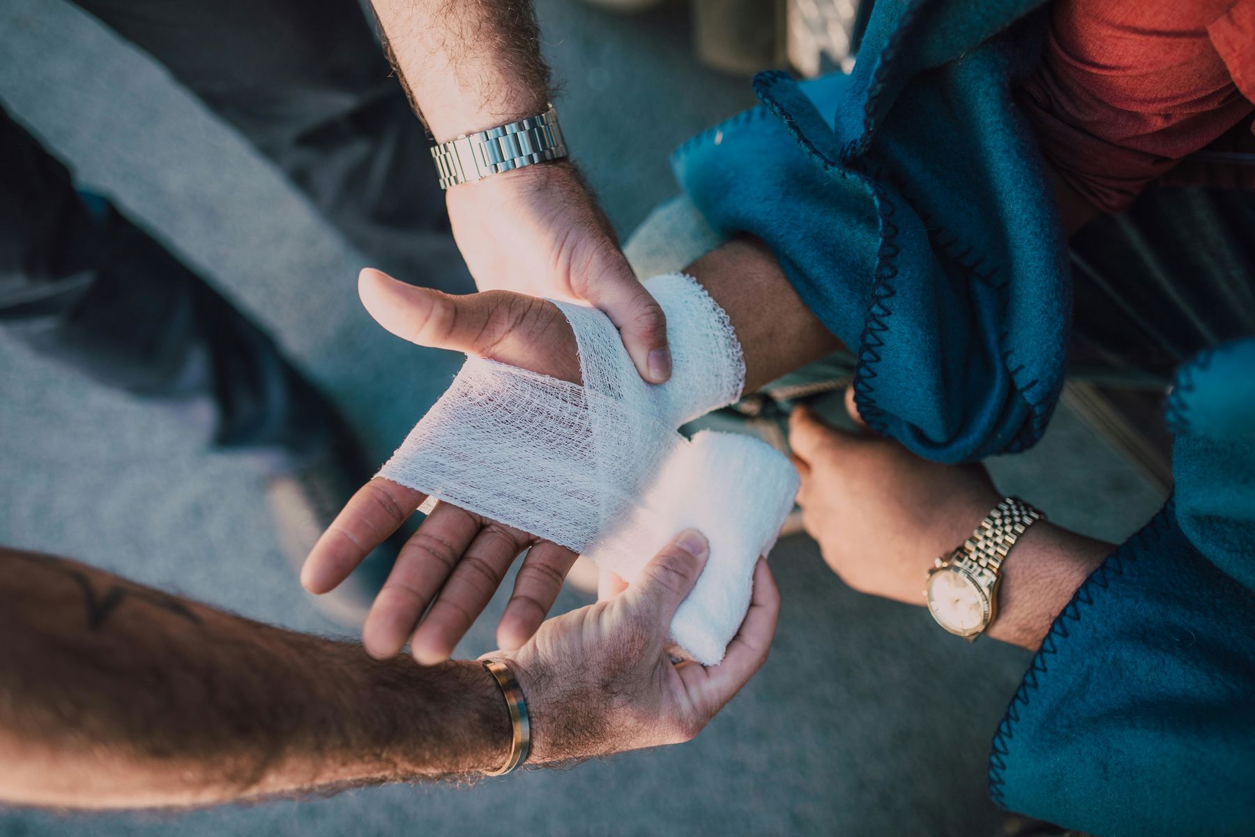 Person applying bandage on another person's hand