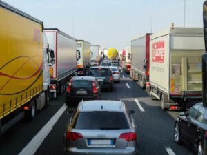 Rows of cars sandwiched to large trucks on the highway