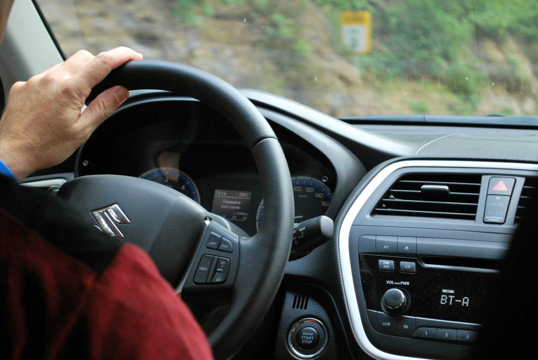 Man with his hand on the steering wheel while driving a car