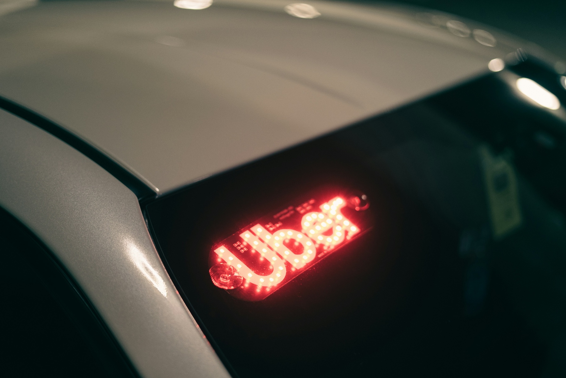 White car with LED Uber signage inside the windshield