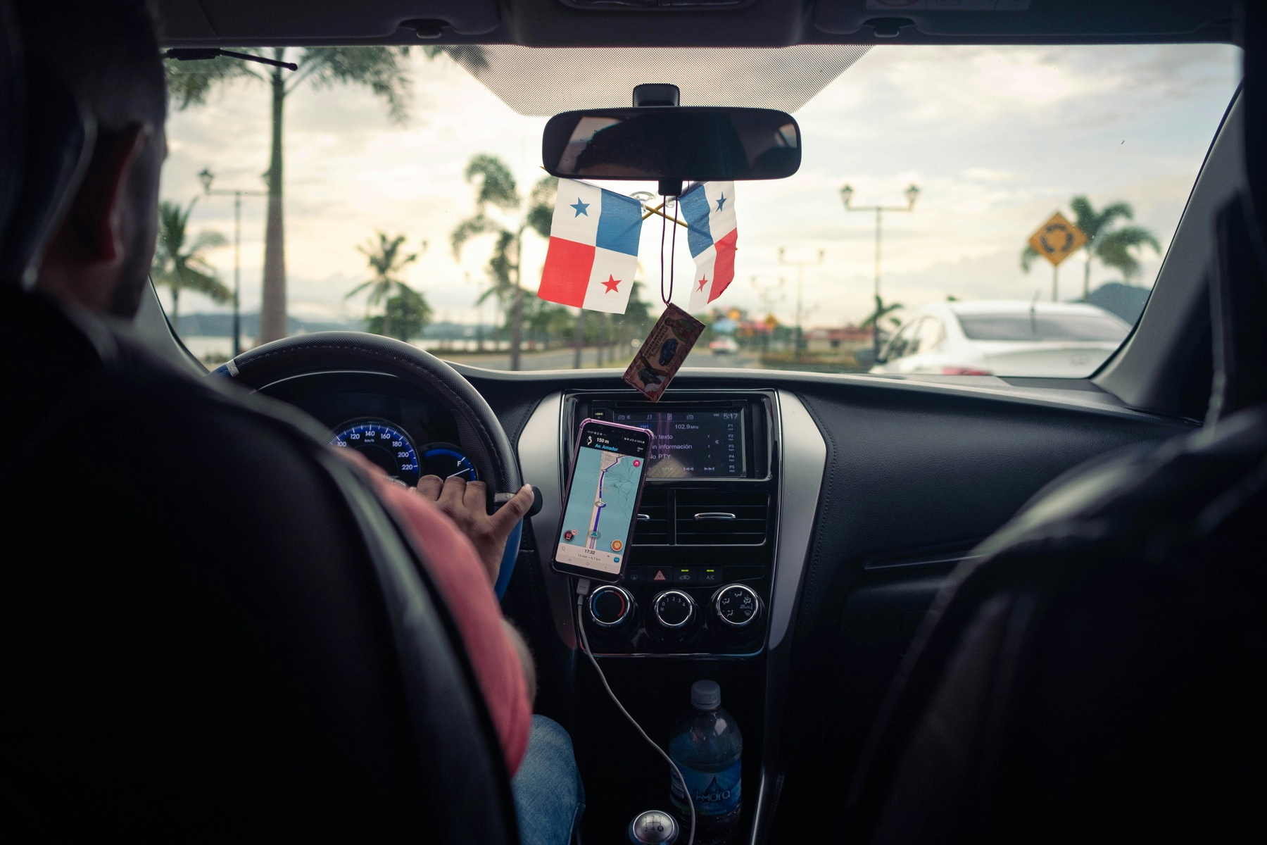 Man driving a car with the help of a GPS installed on his phone