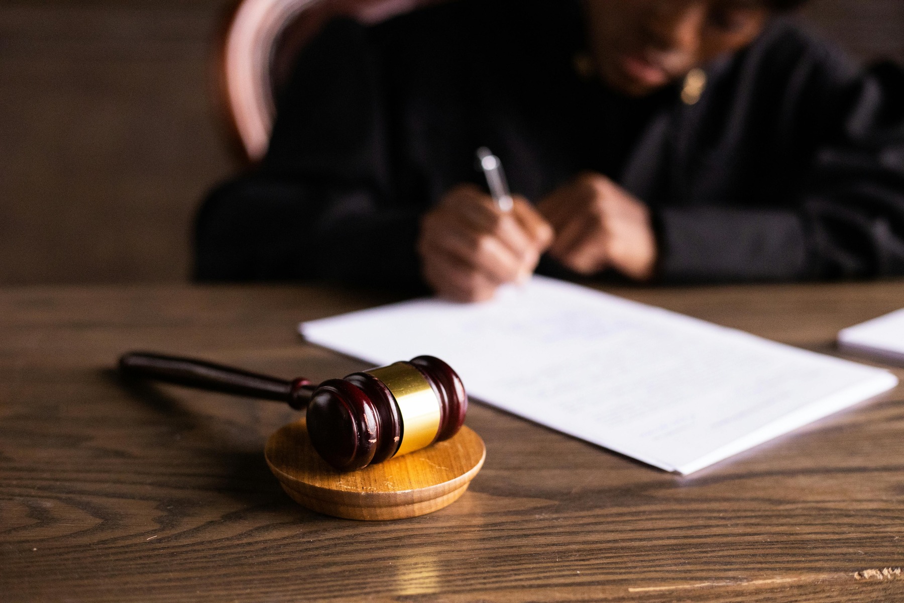 A gavel and an attorney writing on the background