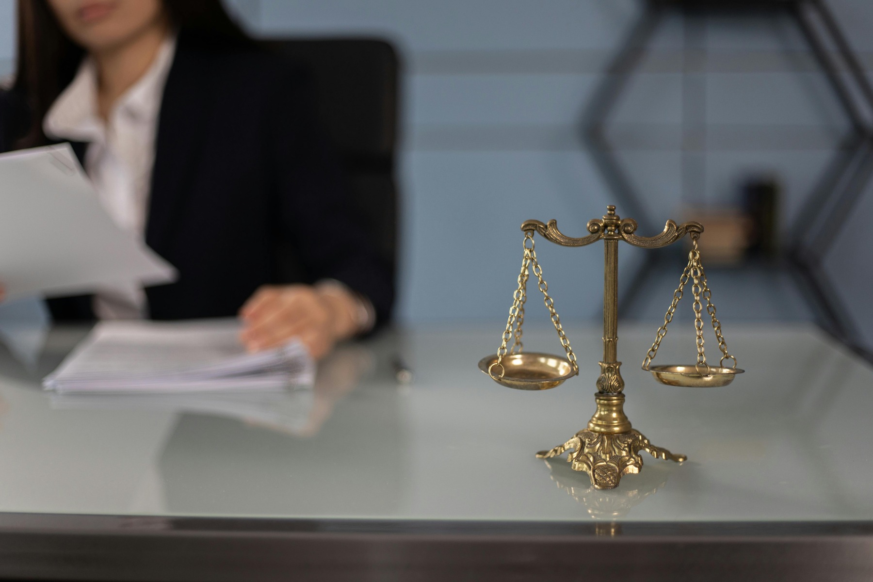 Balance scales on the table with the attorney behind