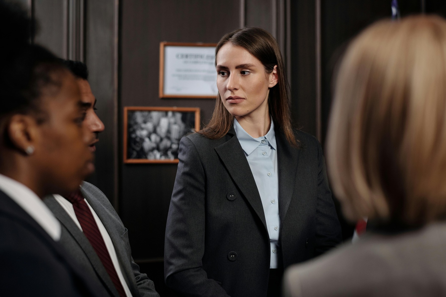 A female attorney in the middle looking at another attorney