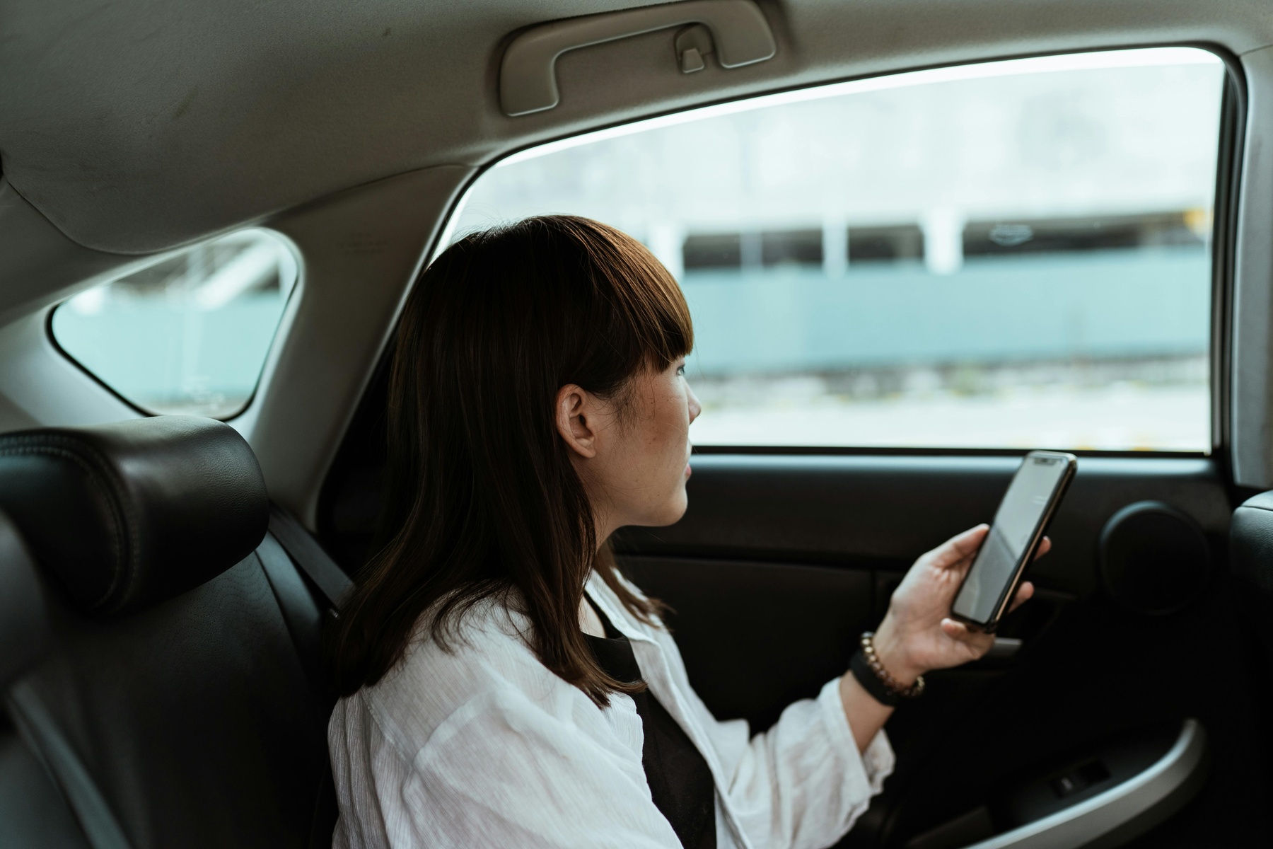 Car passenger checking her phone