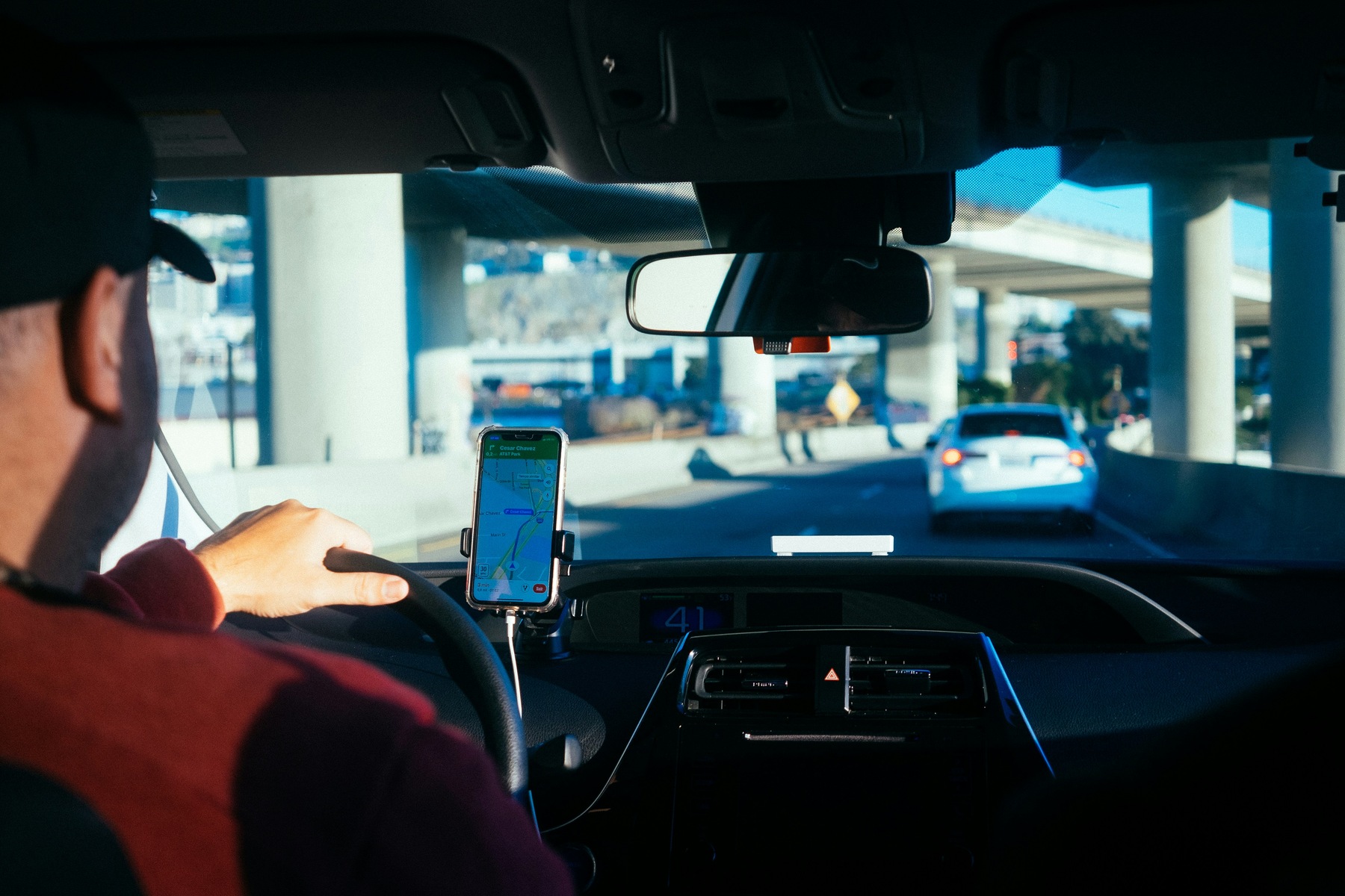 Man driving a car with the help of a navigation system on his phone