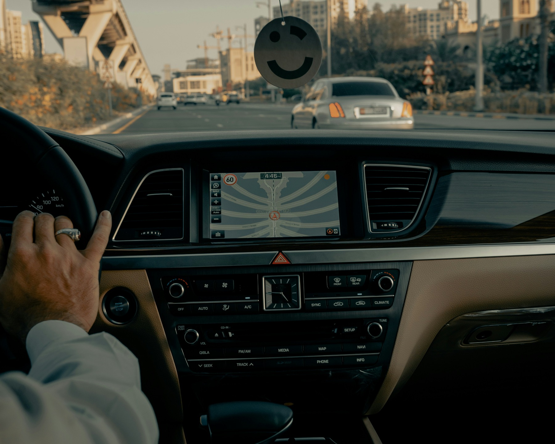 Man with his hand on a steering wheel while driving a car
