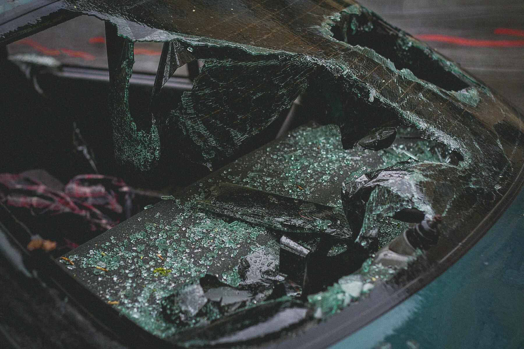 A car with a shattered windshield and a broken window